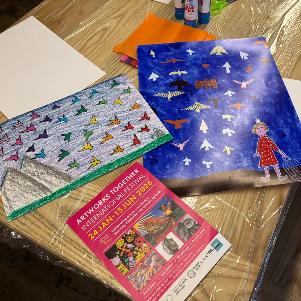 Jodie Cooper Jodie smiling sitting beside her sewing machine in her workspace.