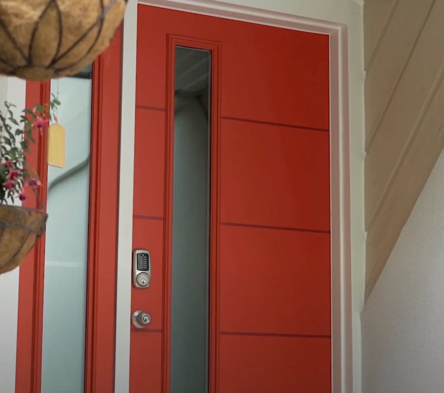Modern red front door with narrow vertical glass panel and electronic keypad lock.