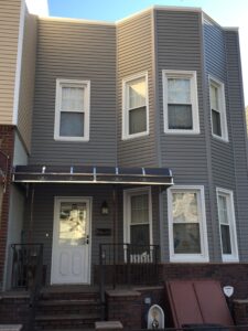 A townhome with tan siding and white framed windows