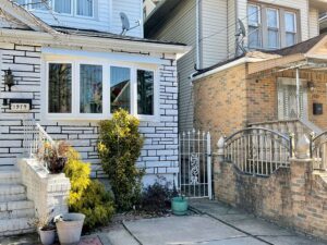 Outside of a home with plants in front of a white bow window
