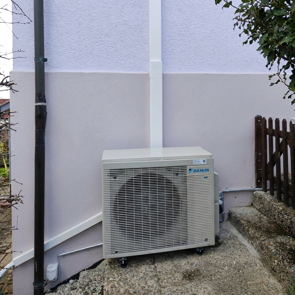 Daikin-Aussengerät am Fuss einer Hausfassade
