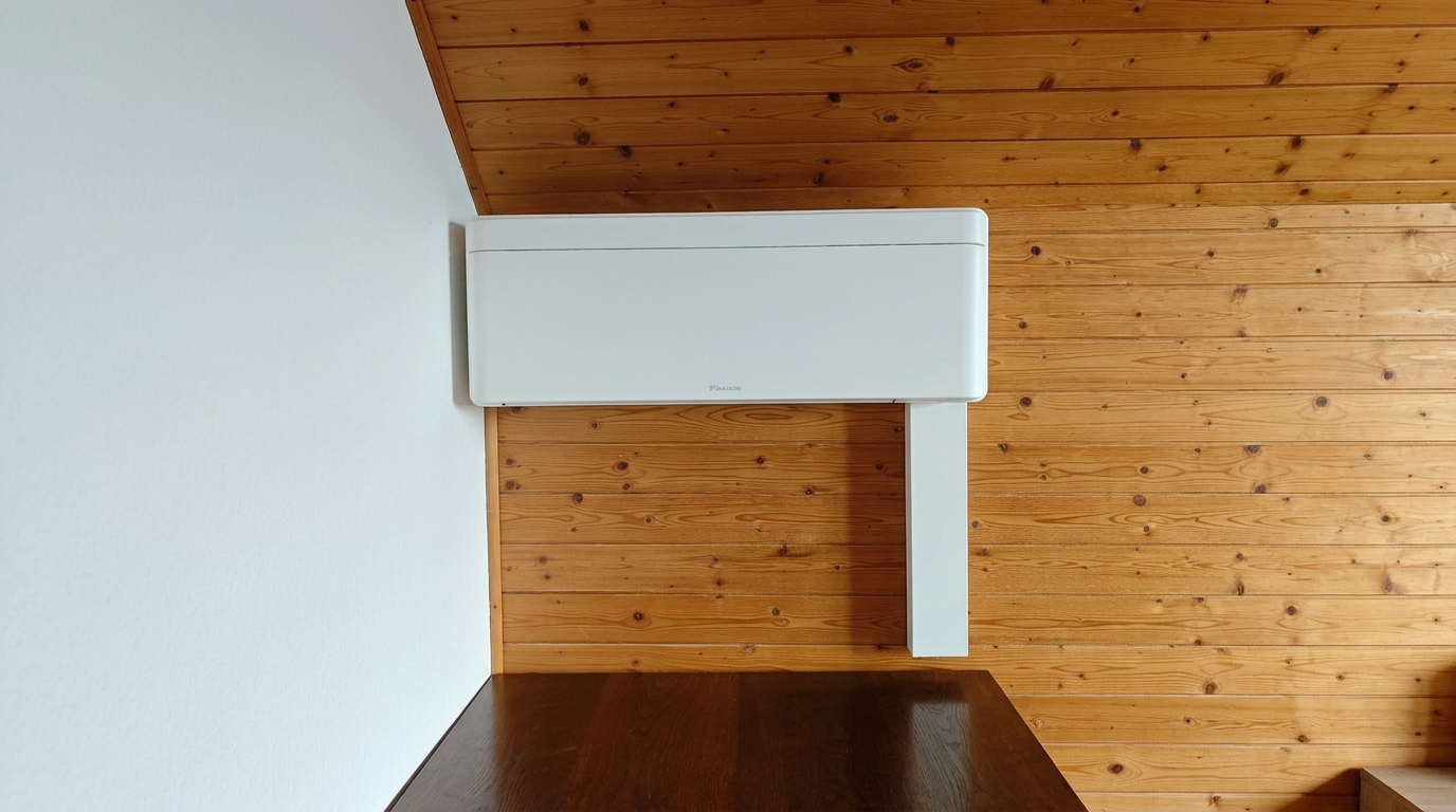 Weisses Innengerät unter der Dachschräge über einer Sitzbank aus Holz