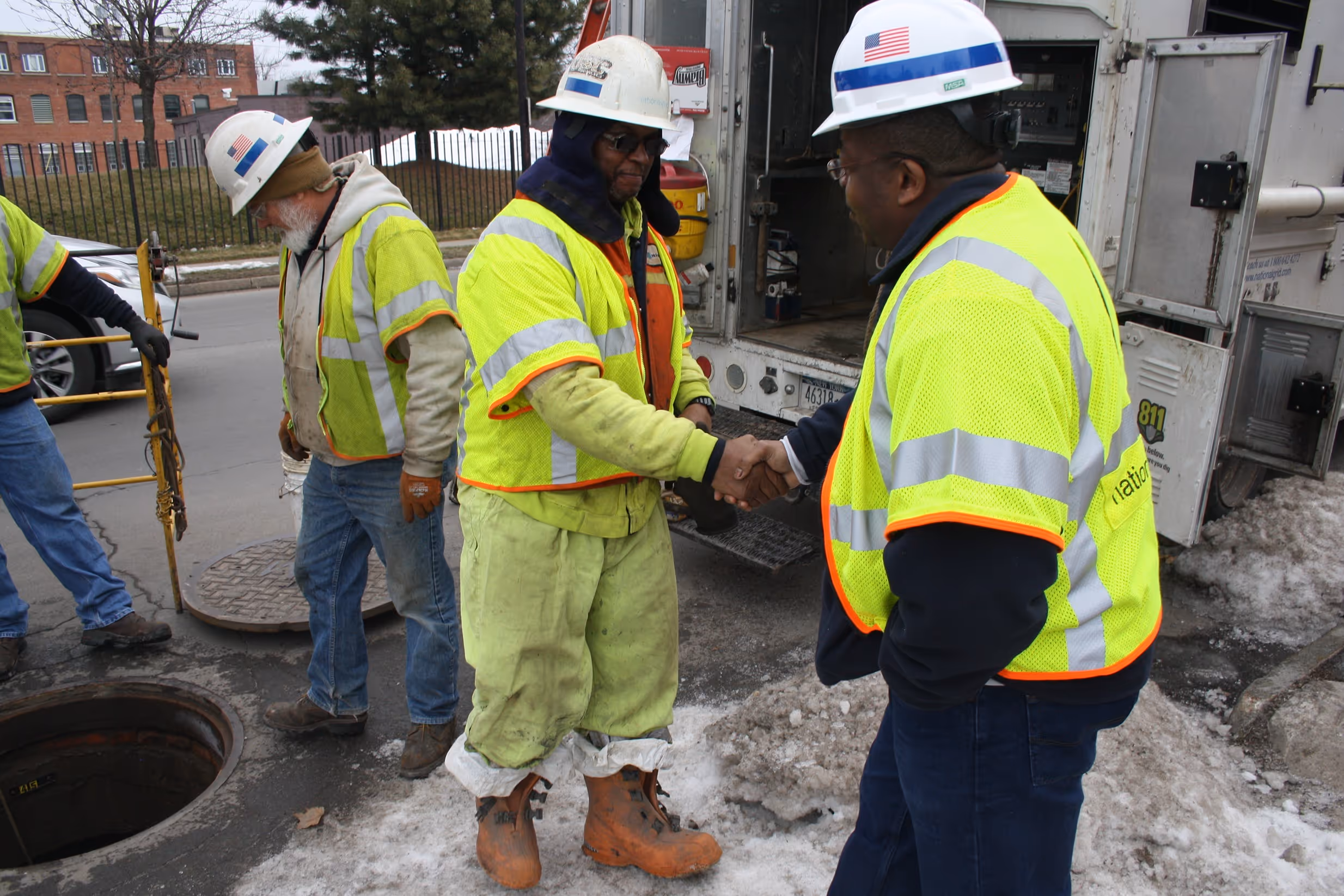 Two electrical workers shaking hands.