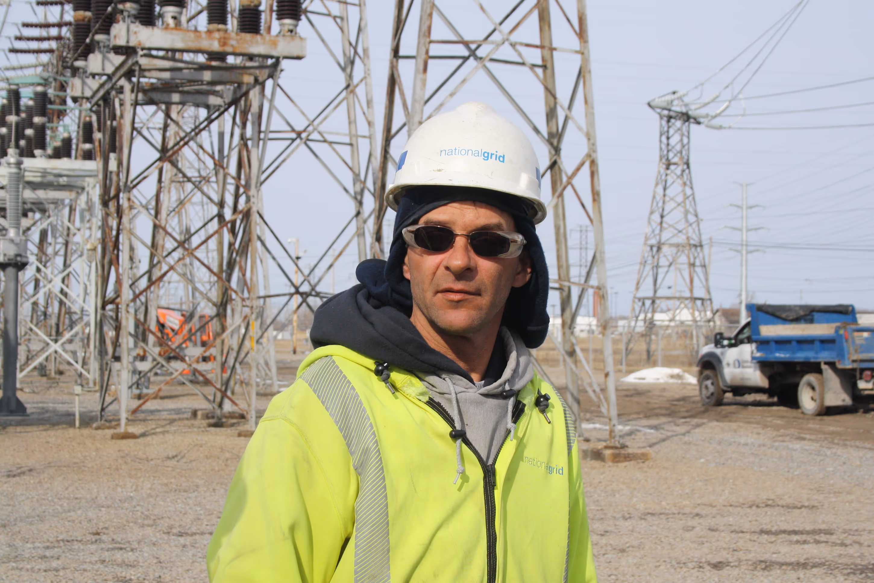 IBEW member standing in front of electrical tower.
