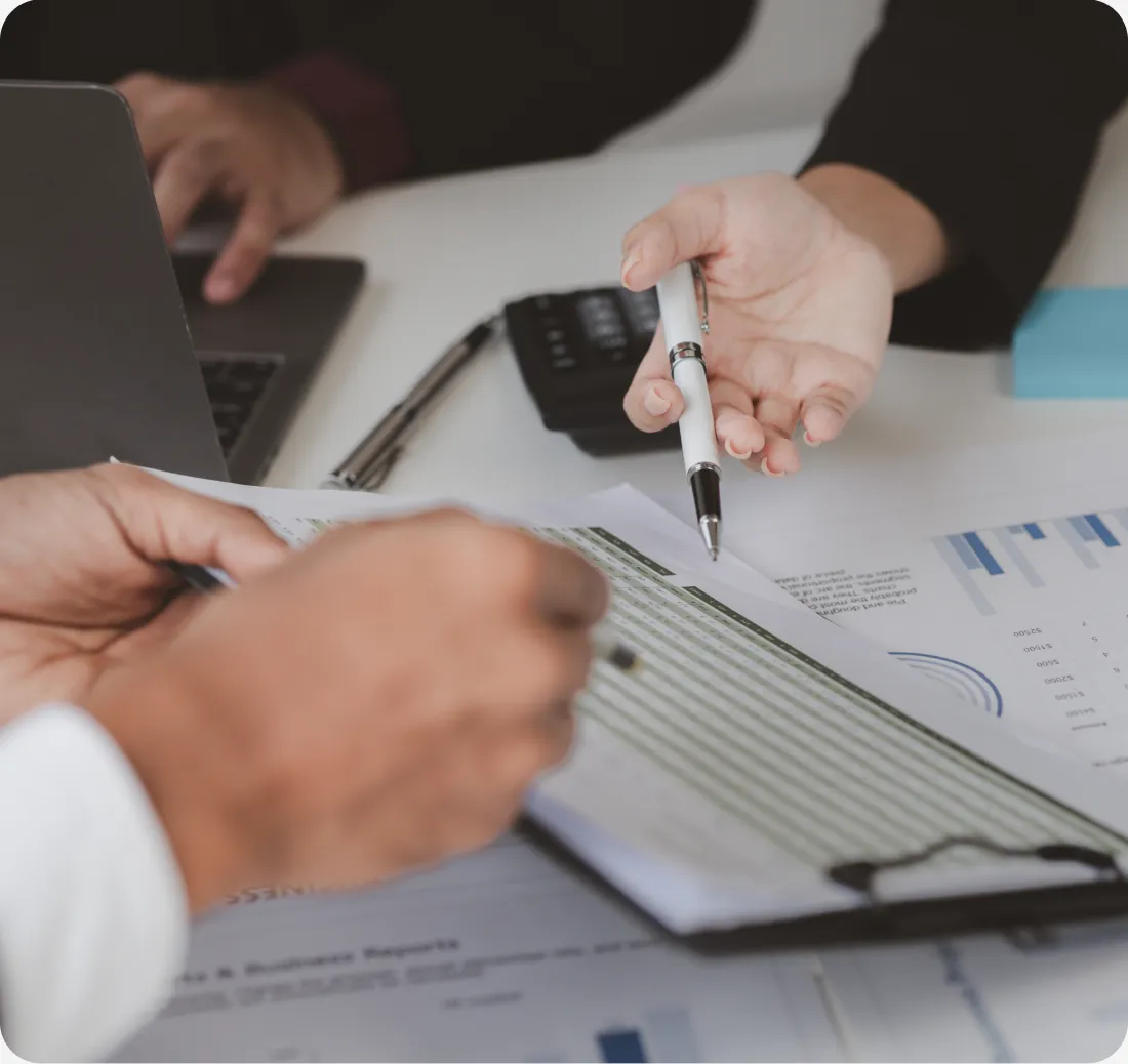 hands discussing financial report with clipboard and charts