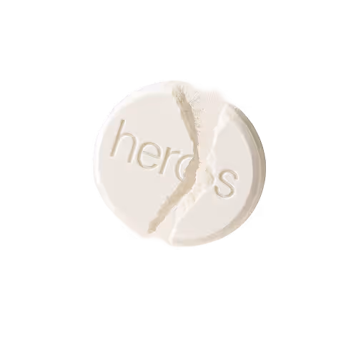 White round tablet broken in half with the word 'heroes' engraved on it.