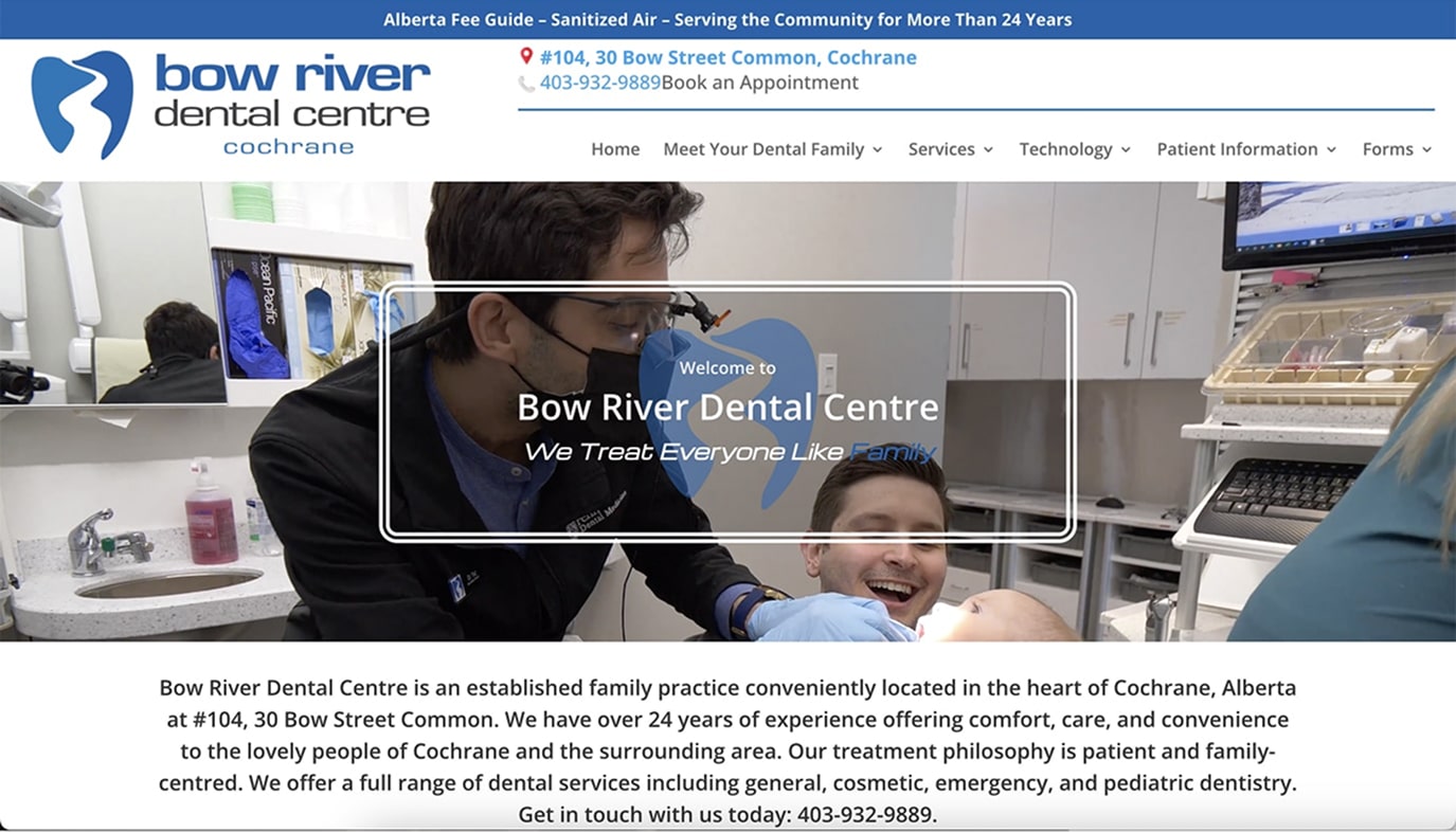 Dentist wearing mask and gloves examining a smiling patient holding a baby in a modern dental clinic.