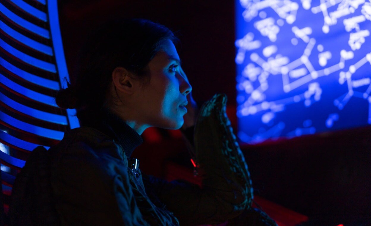 Woman looking at a screen in a dark room