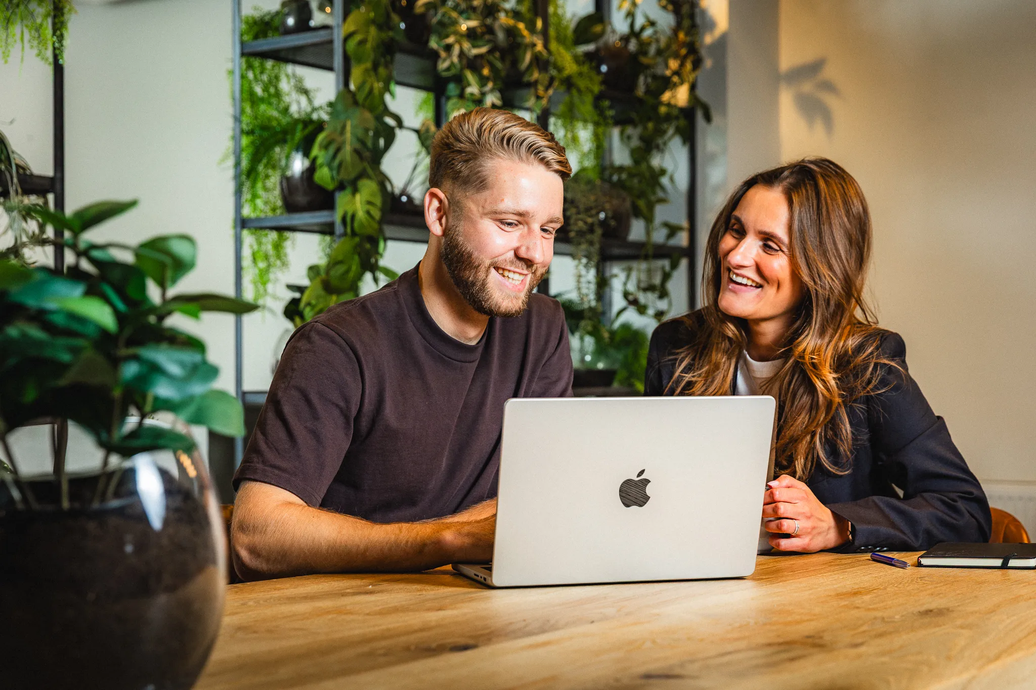 Persoonlijk gesprek tussen designer en klant met open laptop op tafel