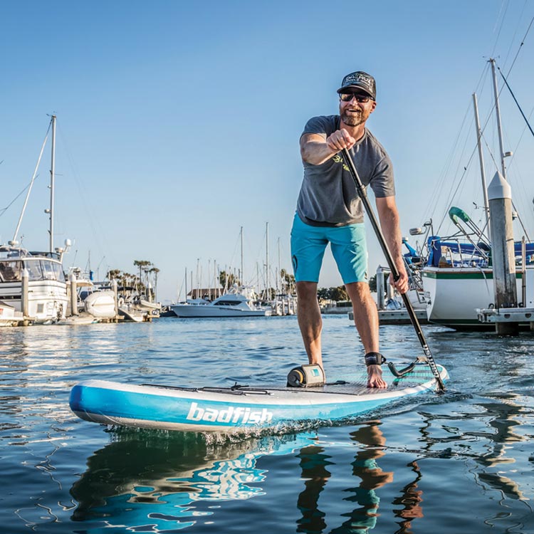 Mike paddleboarding in a harbor.