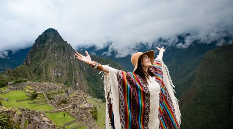 A haoppy woman on top of Machu Picchu
