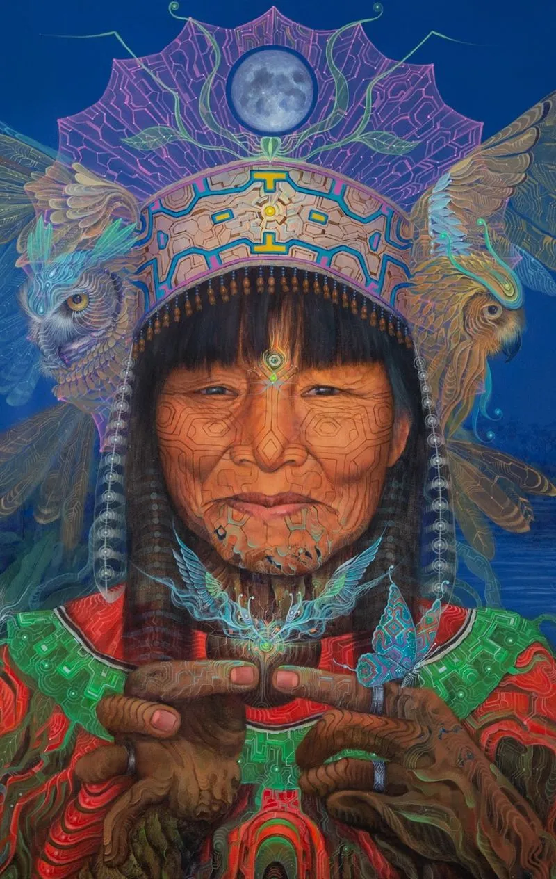 A mystical digital painting of an elder with intricate face markings and sacred symbols, surrounded by ethereal owls, butterflies, and a glowing moon above their headdress. The artwork blends traditional wisdom with spiritual energy.