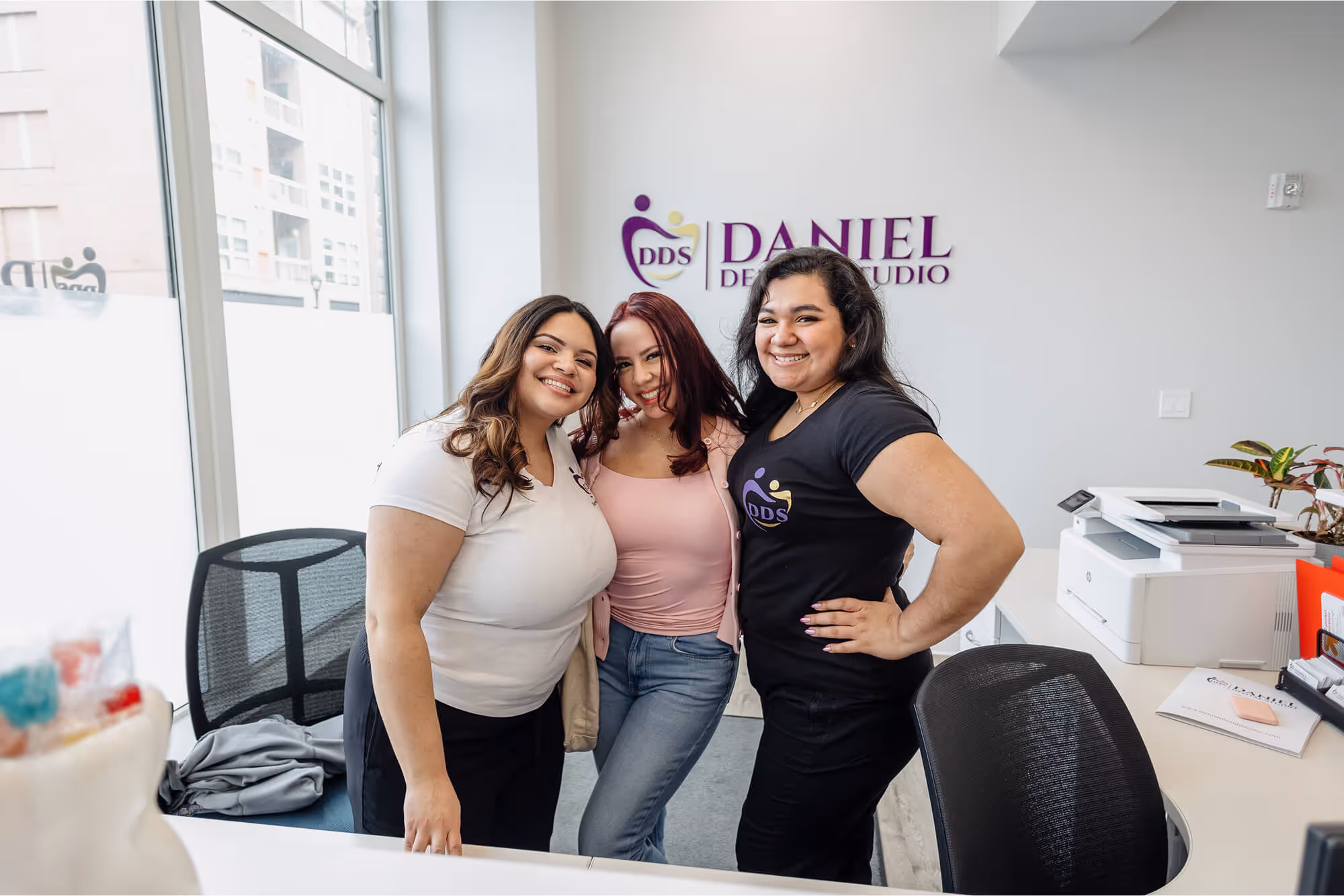 A group of women standing next to each other in an office.
