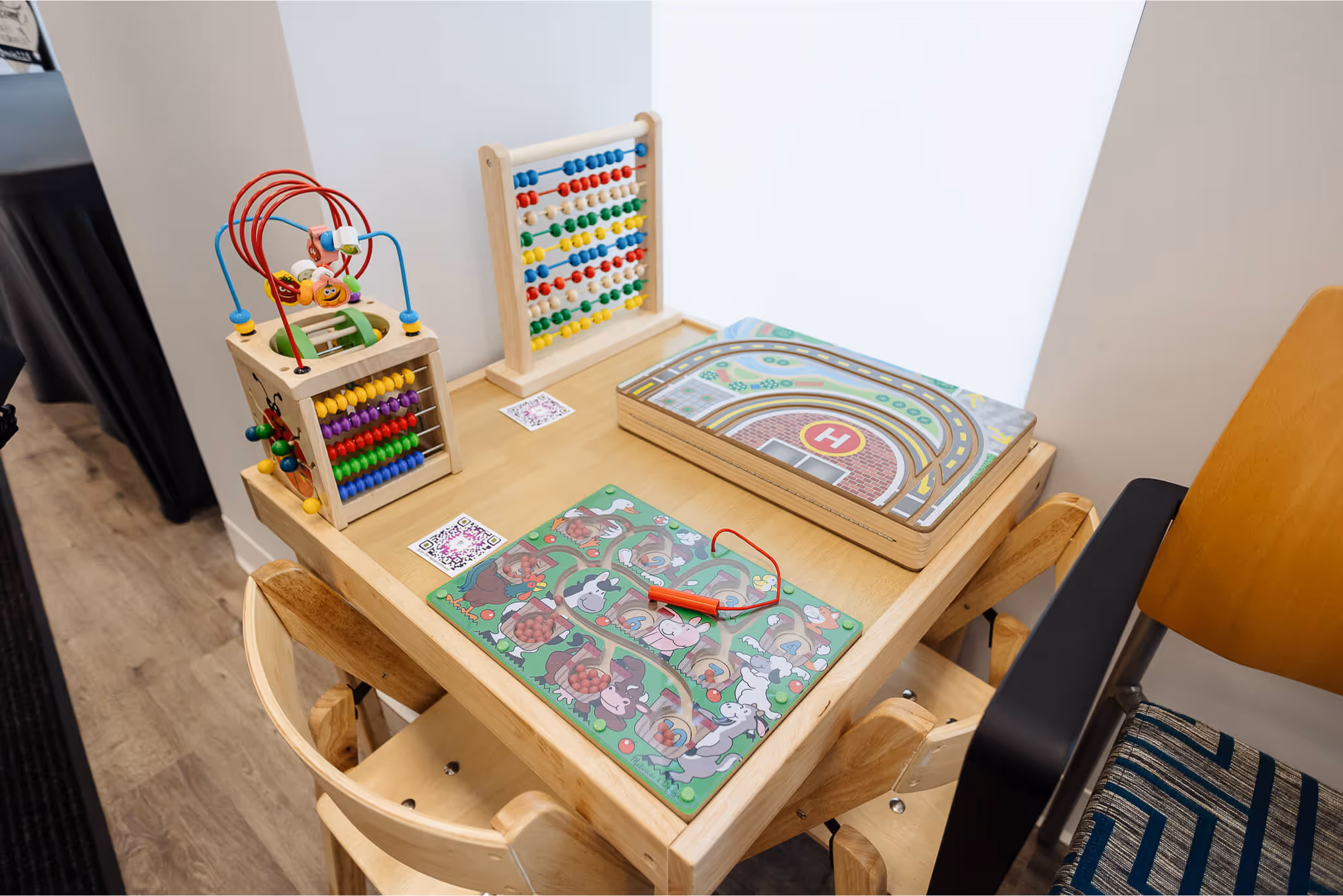 A child's wooden table with a wooden toy set on top of it.
