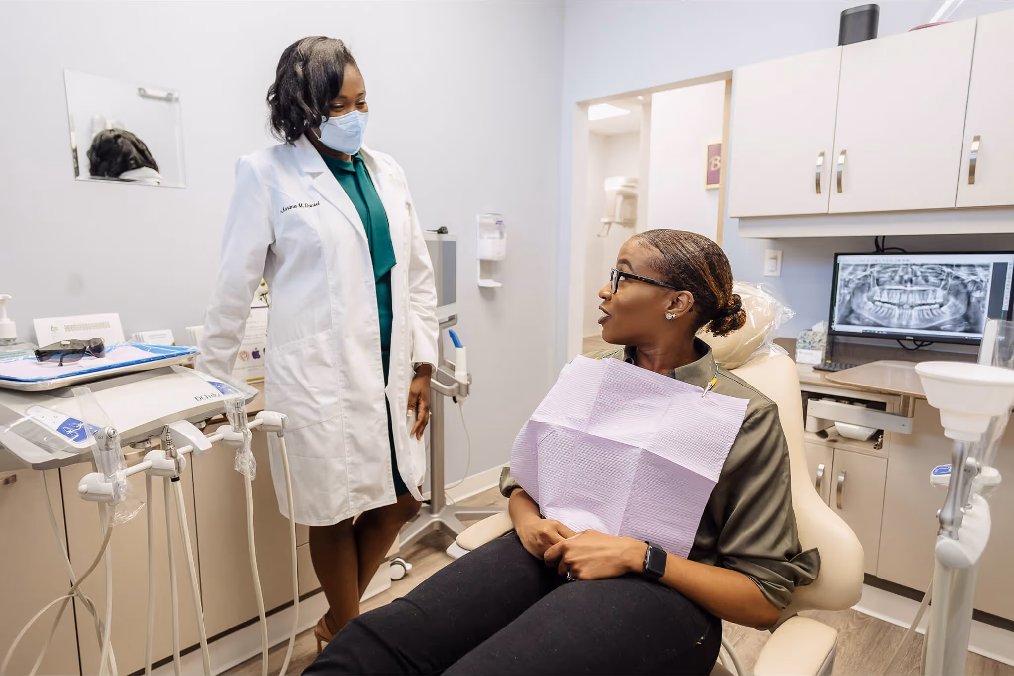 A woman sitting in a chair in a dentist's office.