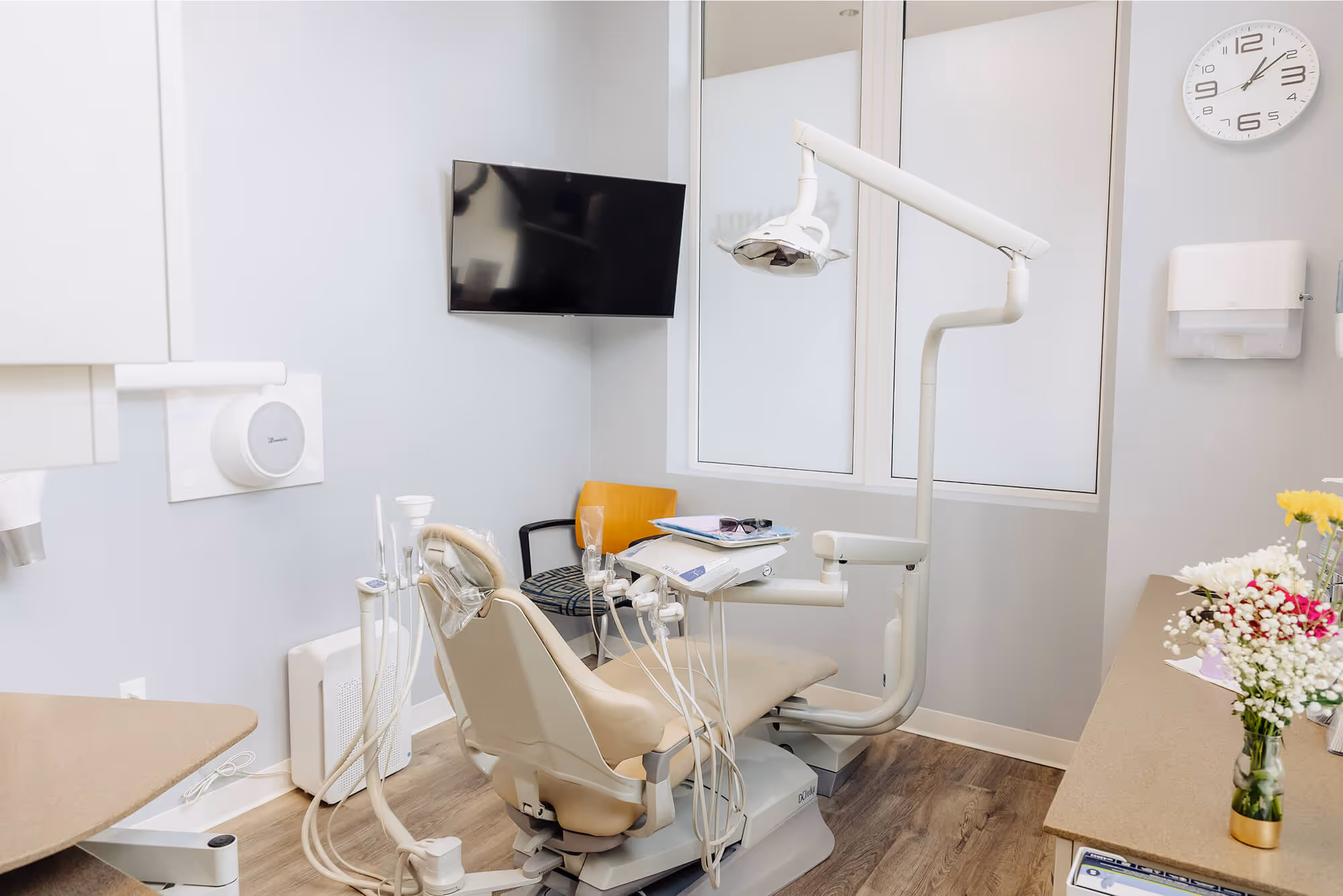 A dental room with a tv and a chair.