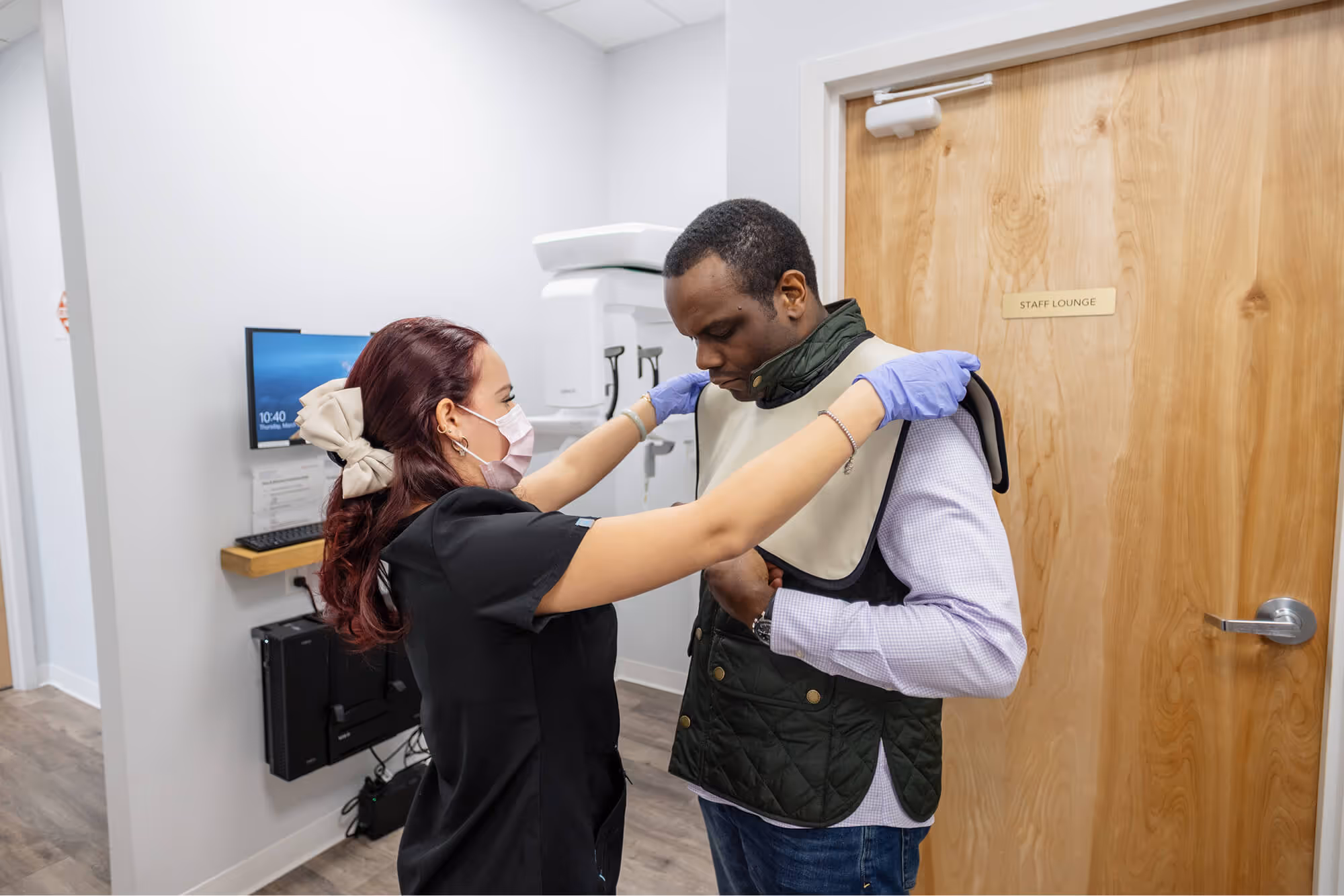 A man helping a woman put on a scarf.