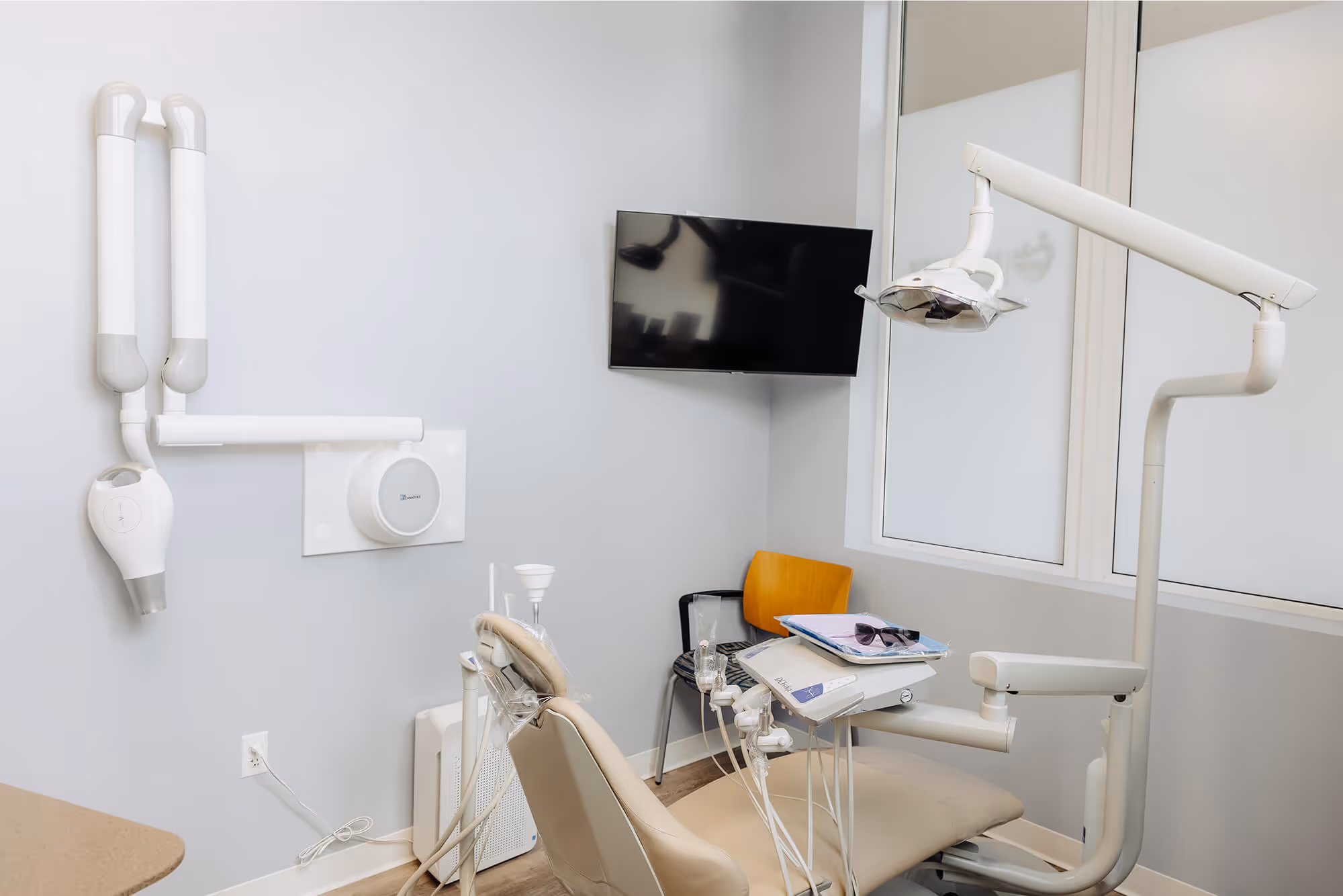 A dental room with a chair and a mirror.