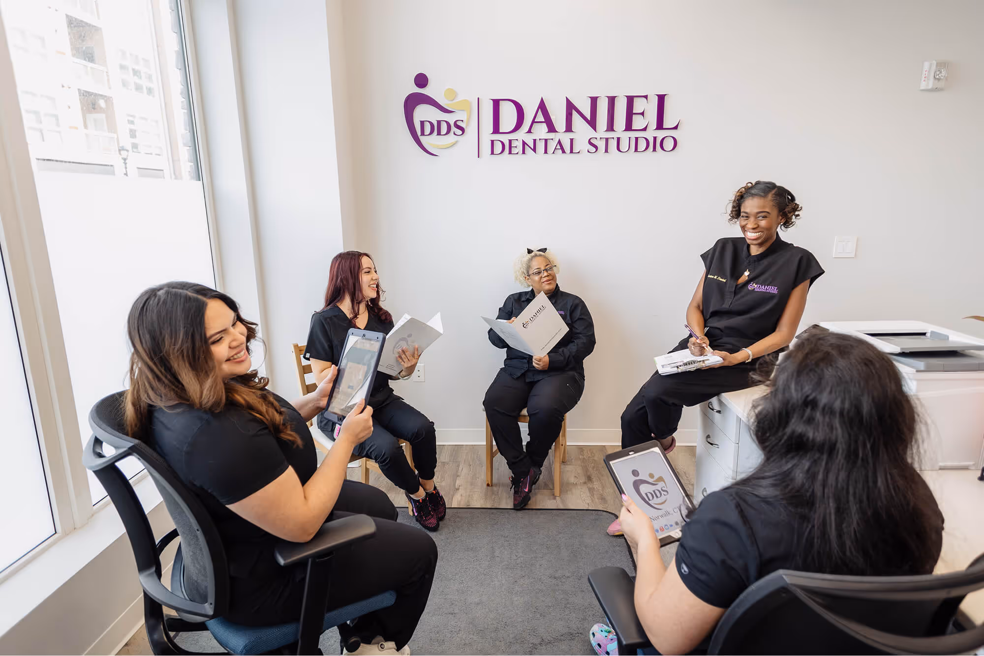 A group of women sitting around each other in a room.