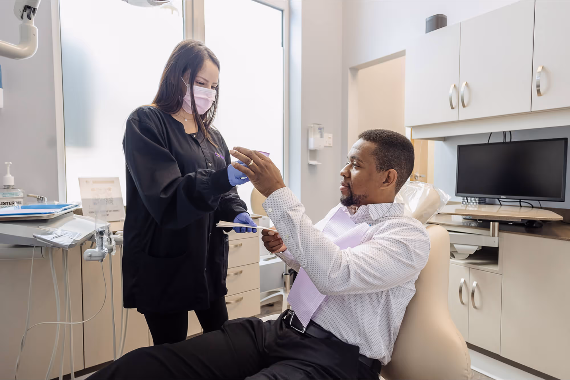 A man getting his teeth checked by a woman.