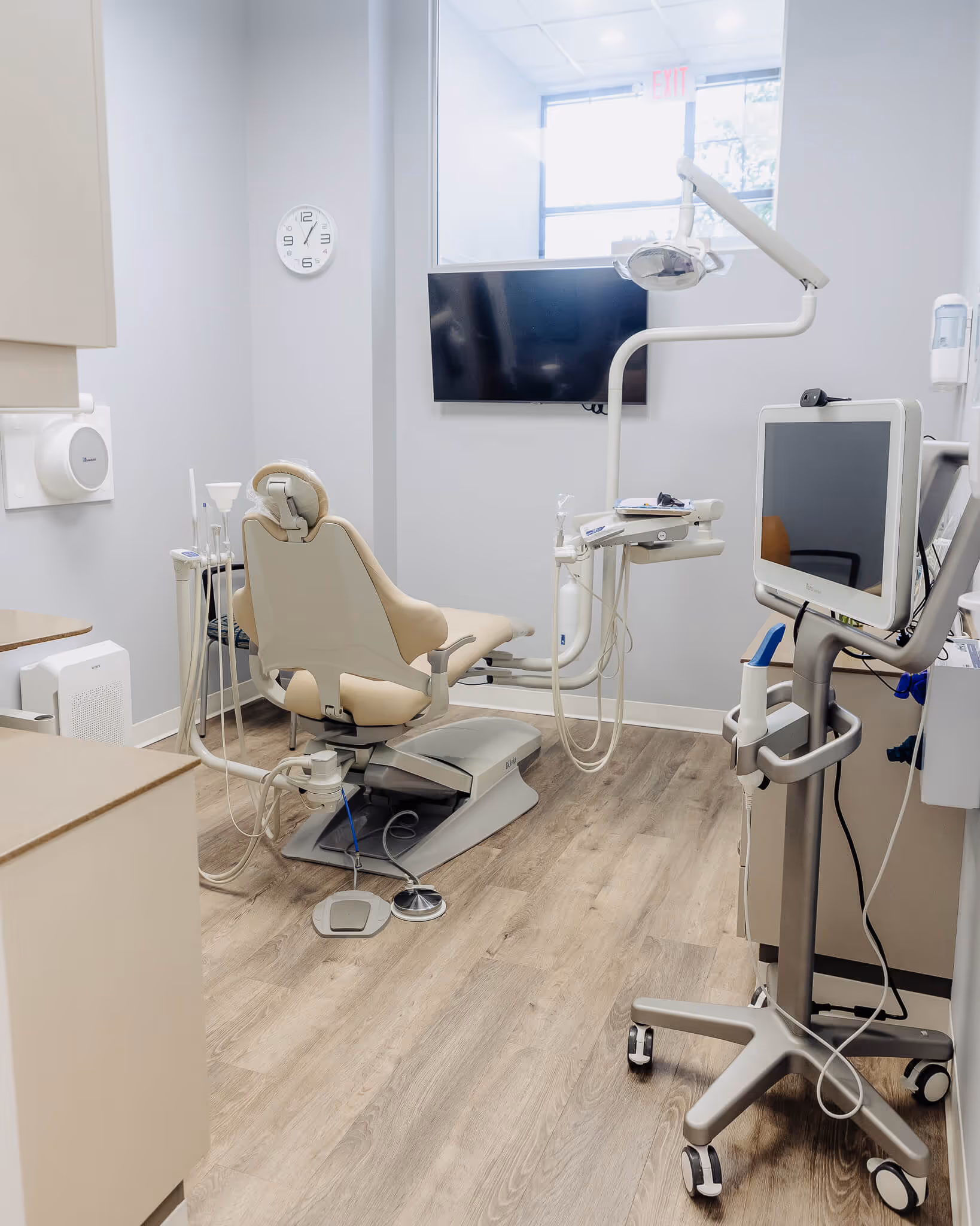 A room with a chair, monitor, and other medical equipment.