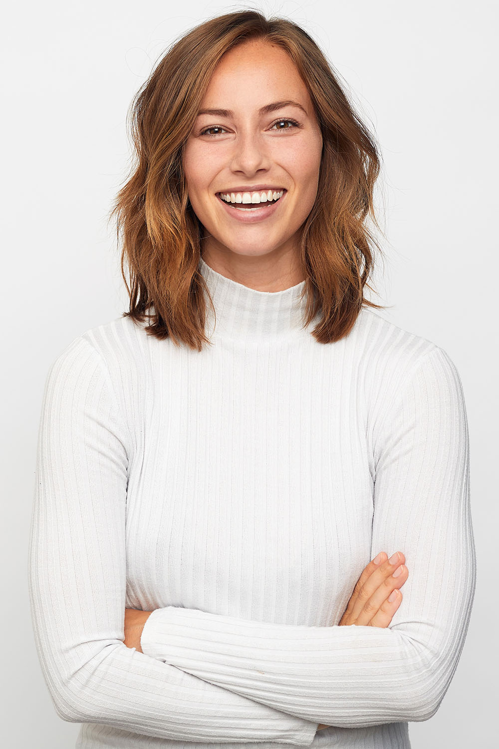 woman in white shirt looking at camera smiling

