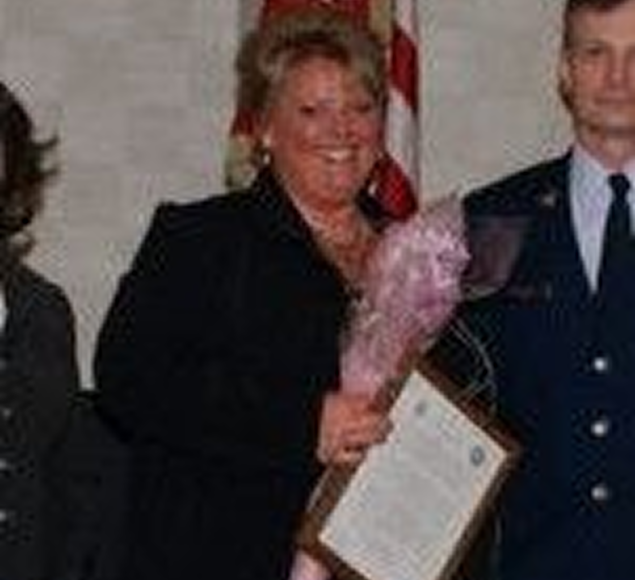 Toni's founder holding flowers and a certificate