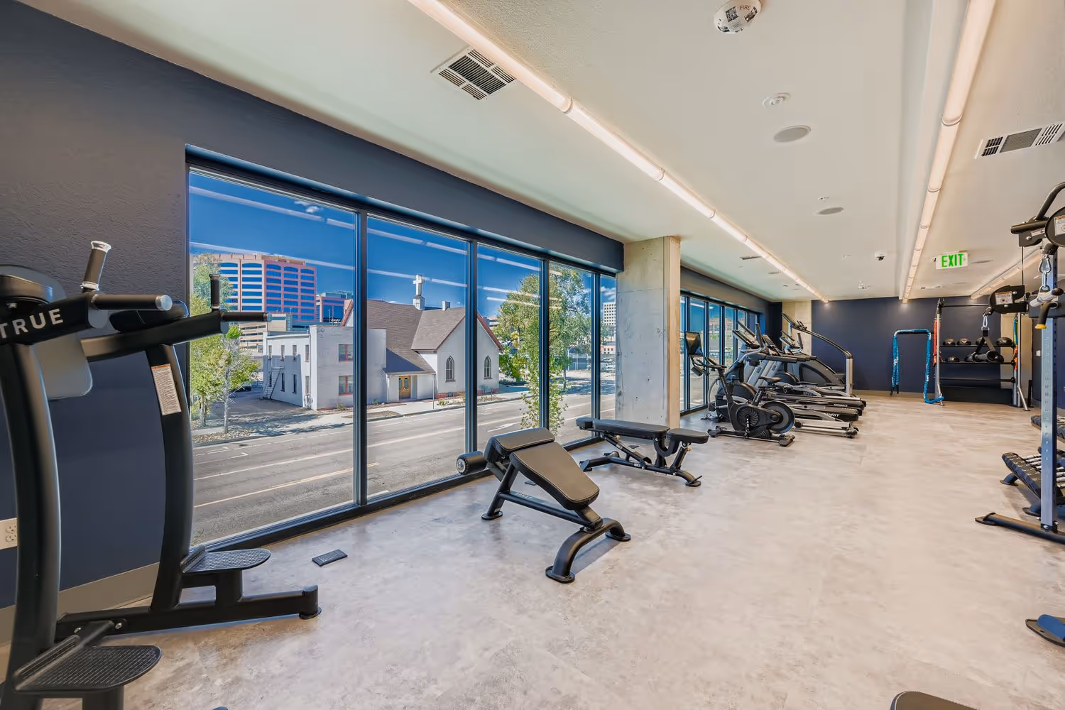 Resident fitness center with weight benches and city views, showcasing high-performance equipment at Avian Apartments in Colorado Springs, CO.