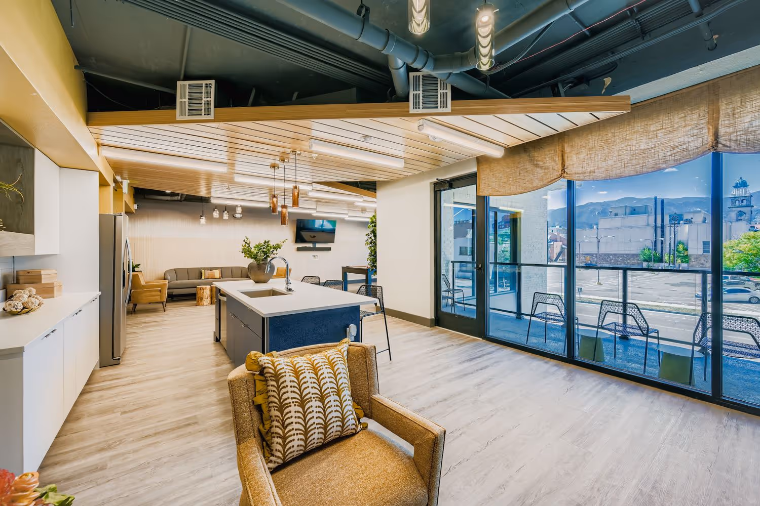 Resident clubhouse kitchen and lounge area with a large island and ample seating, perfect for social gatherings at Avian Apartments in Colorado Springs, CO.