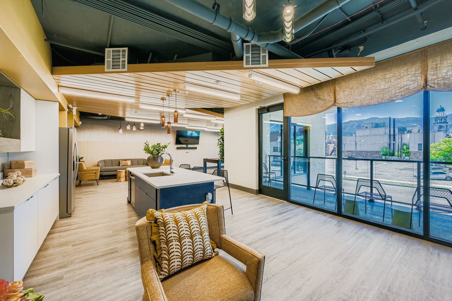 Resident clubhouse kitchen and lounge area with a large island and ample seating, perfect for social gatherings at Avian Apartments in Colorado Springs, CO.