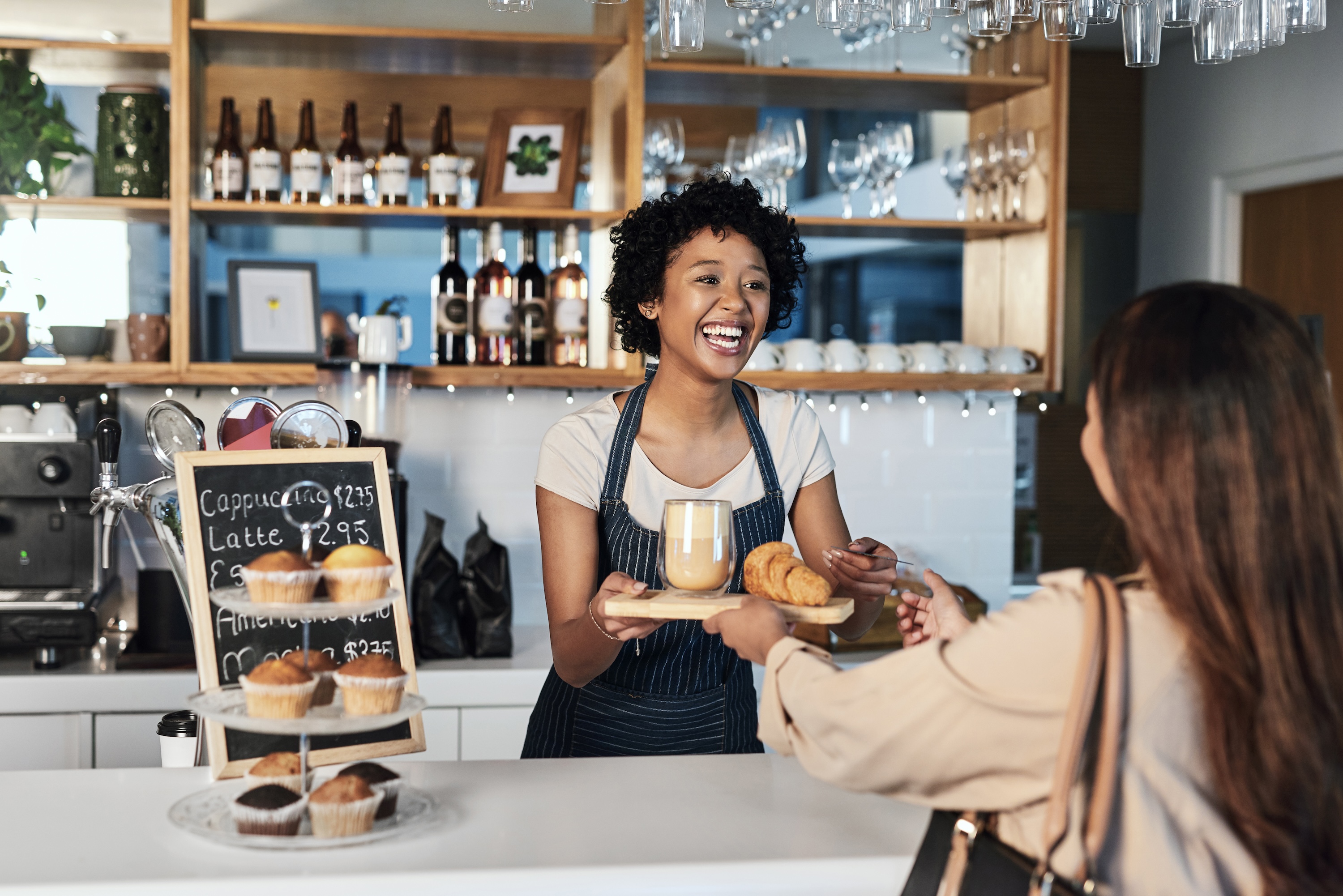 A resident buying coffee and a pastry at a cafe near Avian Apartments in Colorado Springs, CO.