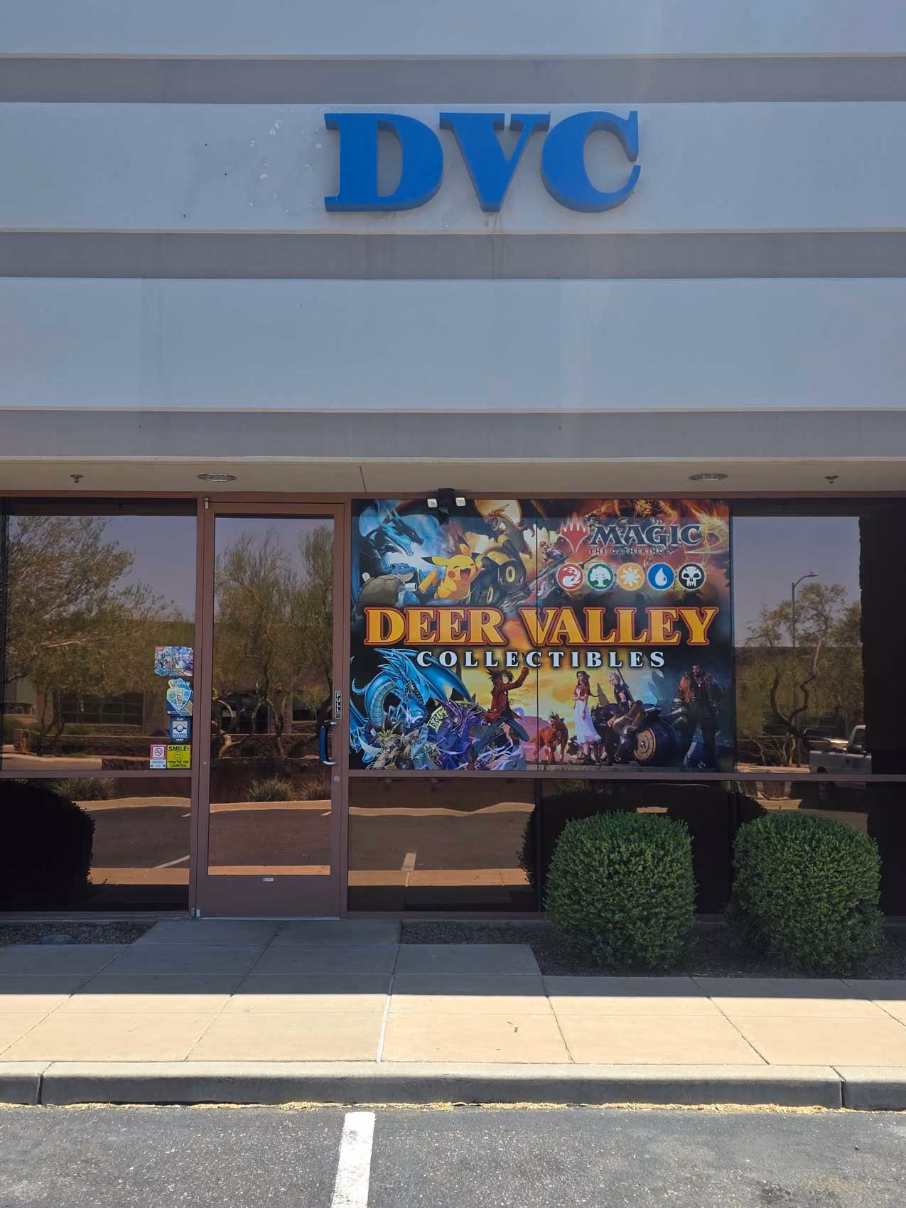 Storefront with a sign reading Deer Valley Collectibles and featuring Magic the Gathering and Pokémon characters.