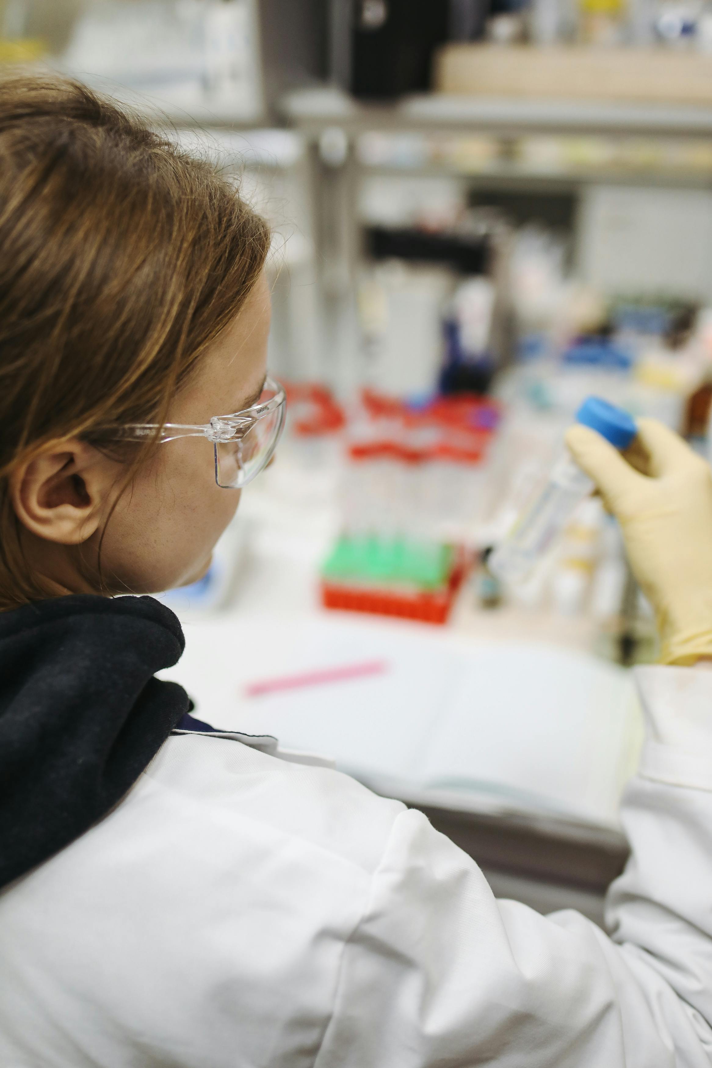 Lab technician examining a test tube in a clinical setting.