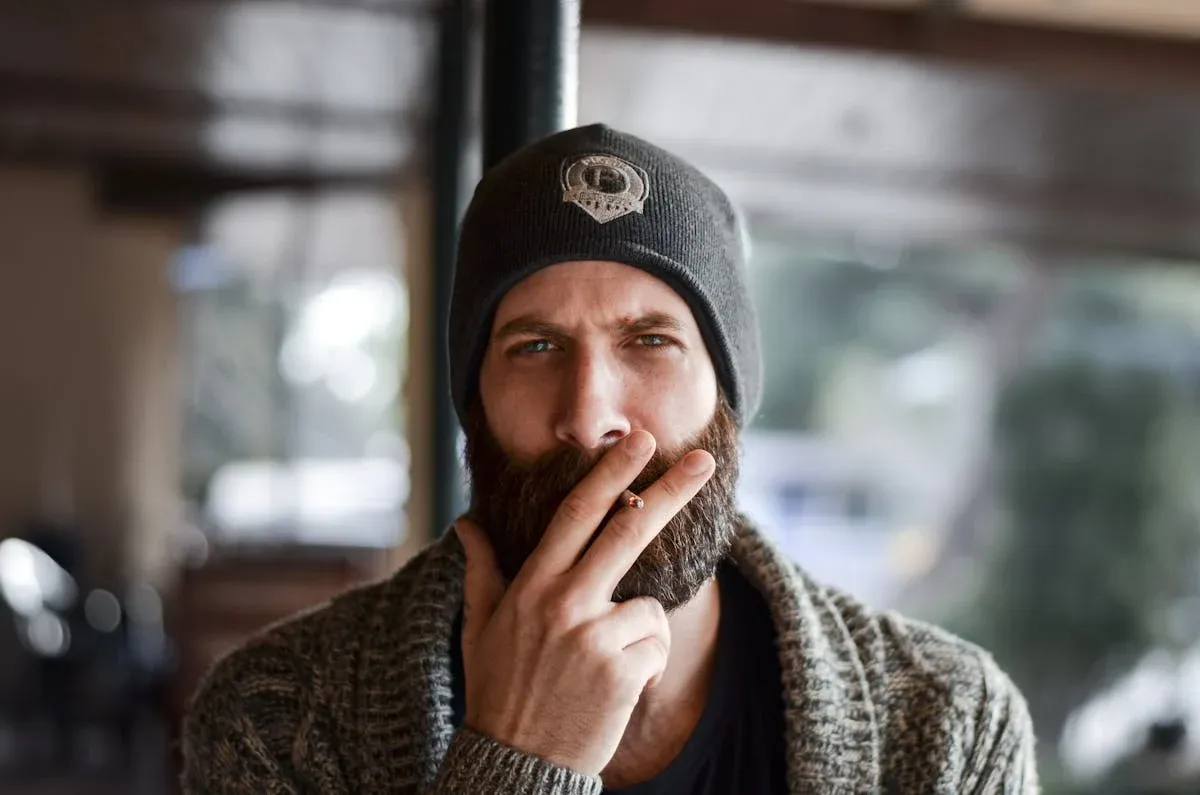 A man with a beard, smiling thoughtfully in the warm light