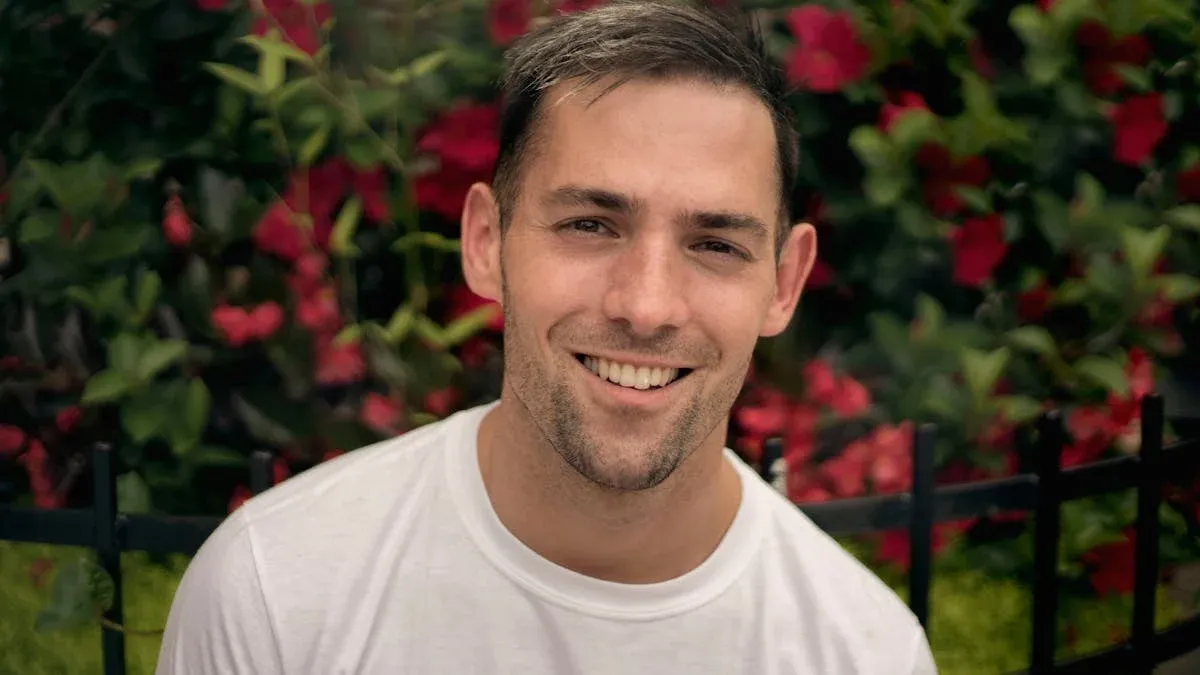 A young man smiles in nature