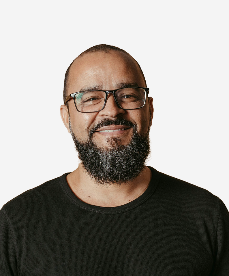 Bearded man in glasses smiling, finding AI-guided answers for chronic migraine symptoms.