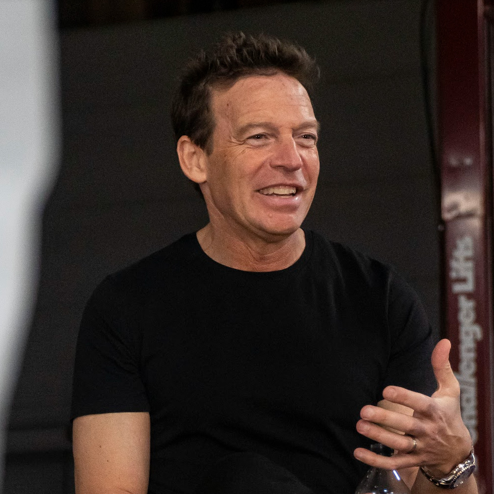 Kelly Smith — man in a black t-shirt smiling and gesturing, Founder & CEO of Hedfirst.