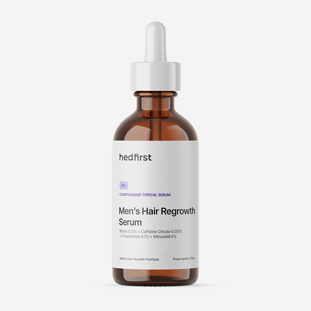 Amber dropper bottle labeled Hedfirst Men's Hair Regrowth Serum with white label, photographed on white background.