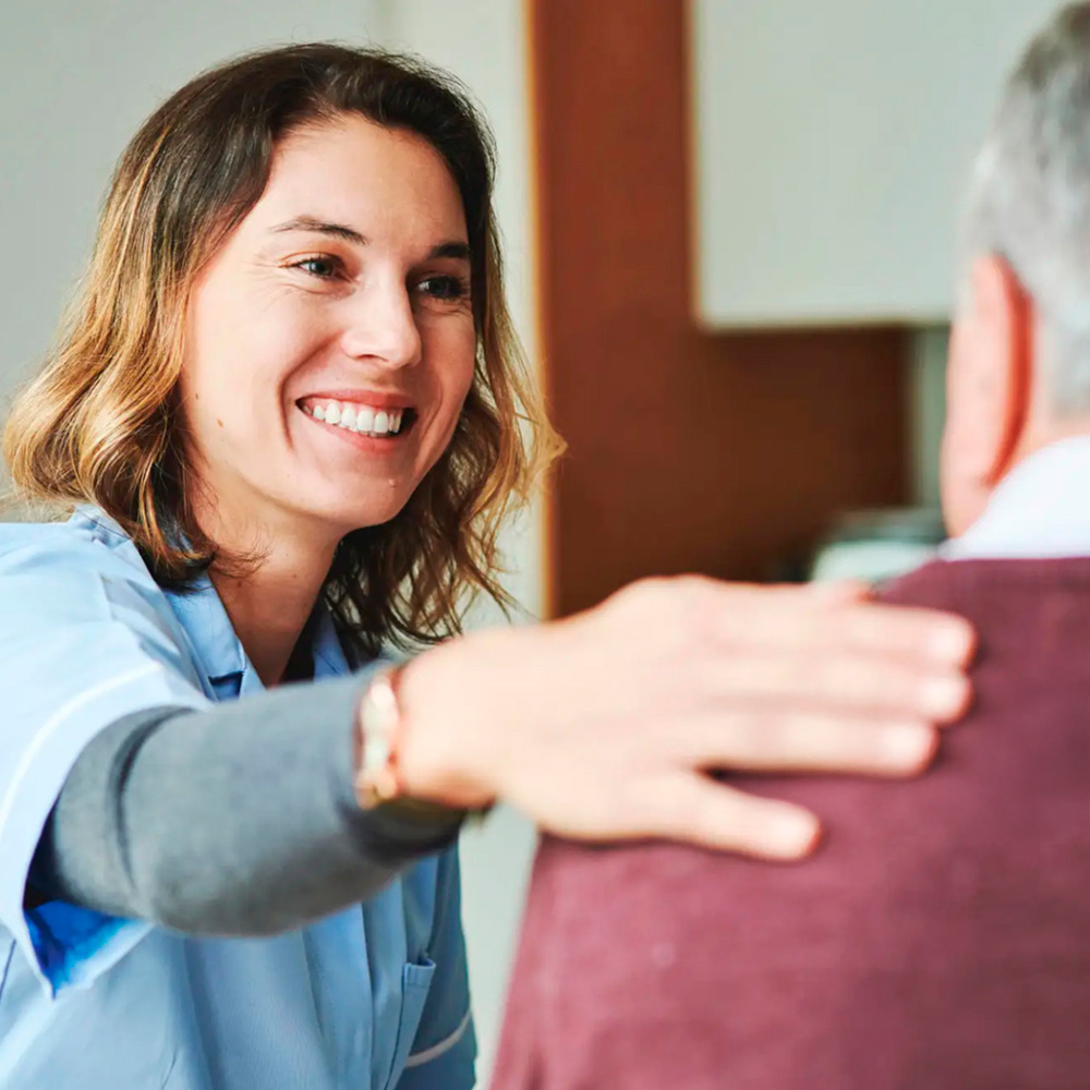 Smiling healthcare provider supporting a patient during gout treatment consultation.
