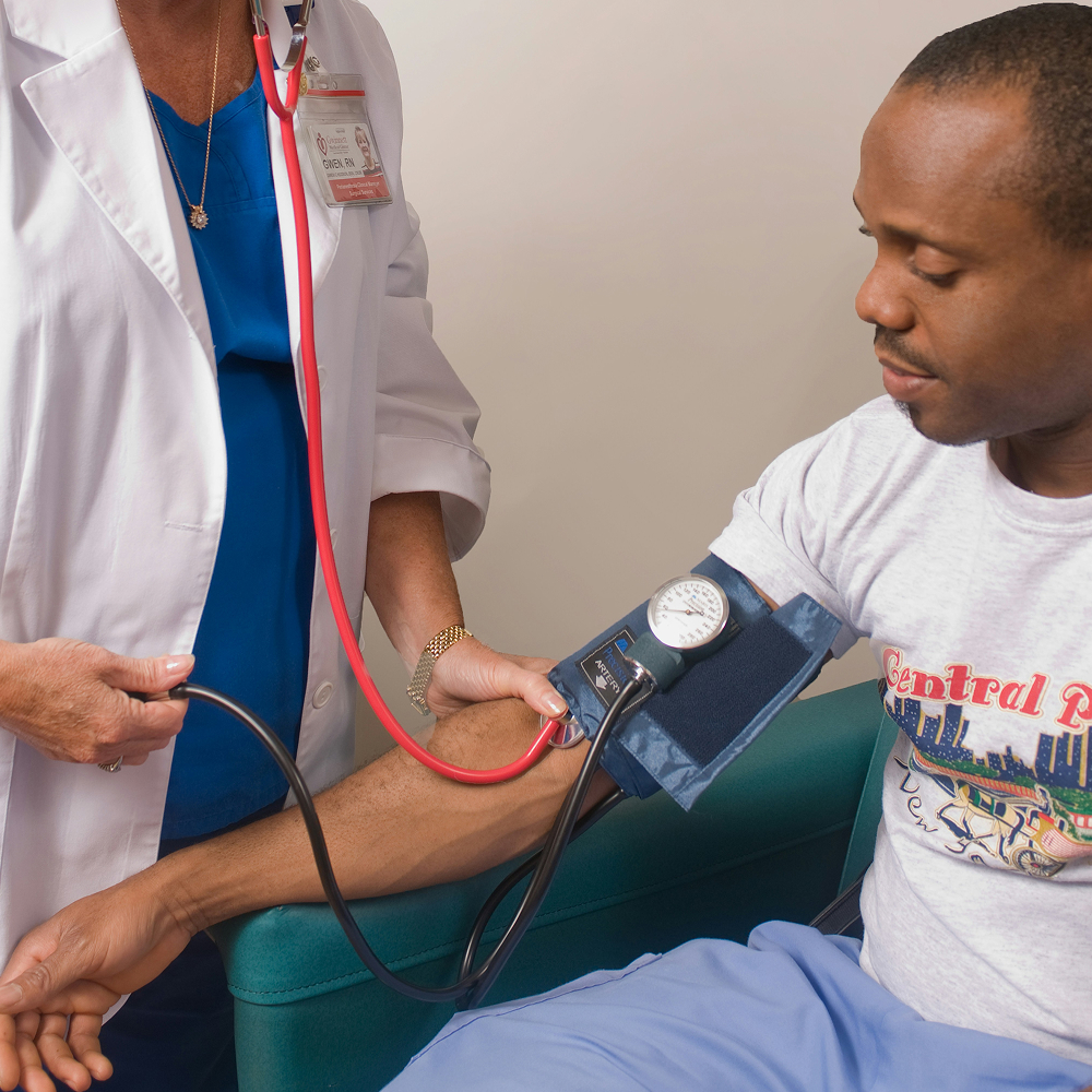 Doctor checking a patient's blood pressure to monitor heart health.