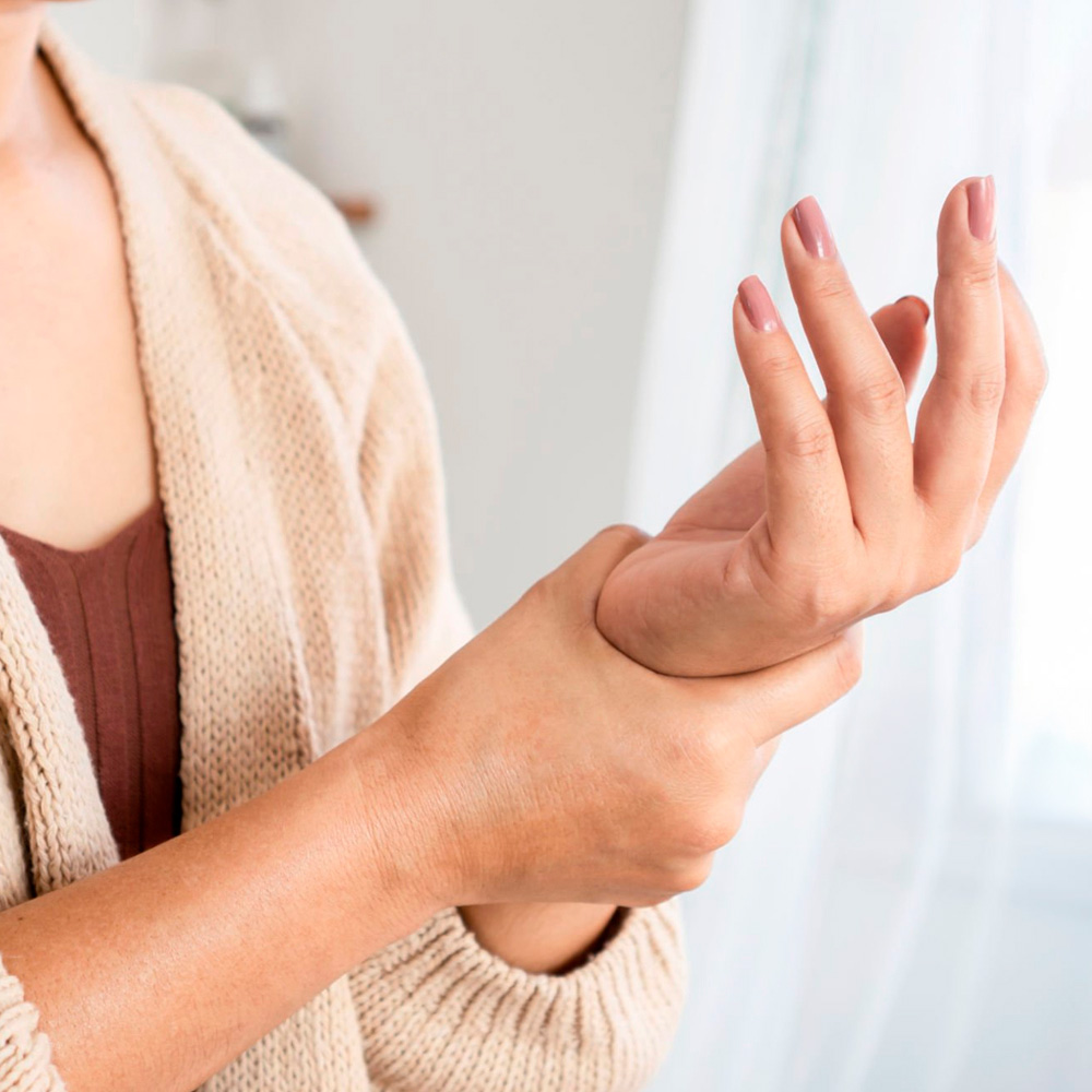 Woman holding her wrist, possibly experiencing tingling or numbness.