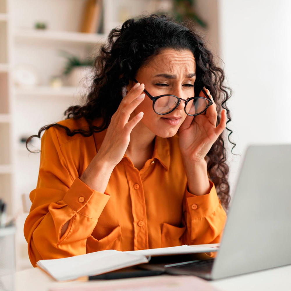 Woman experiencing vision problems while using laptop.