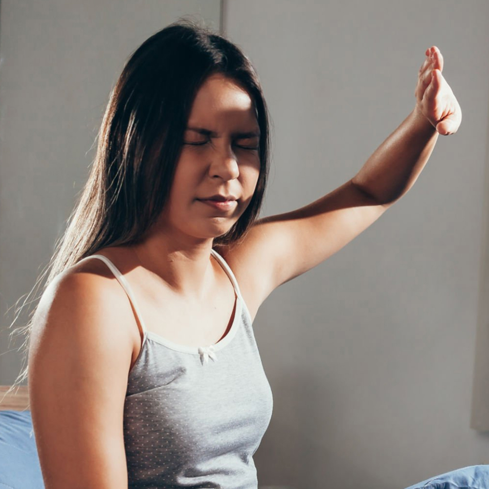Woman experiencing light sensitivity in the morning light.