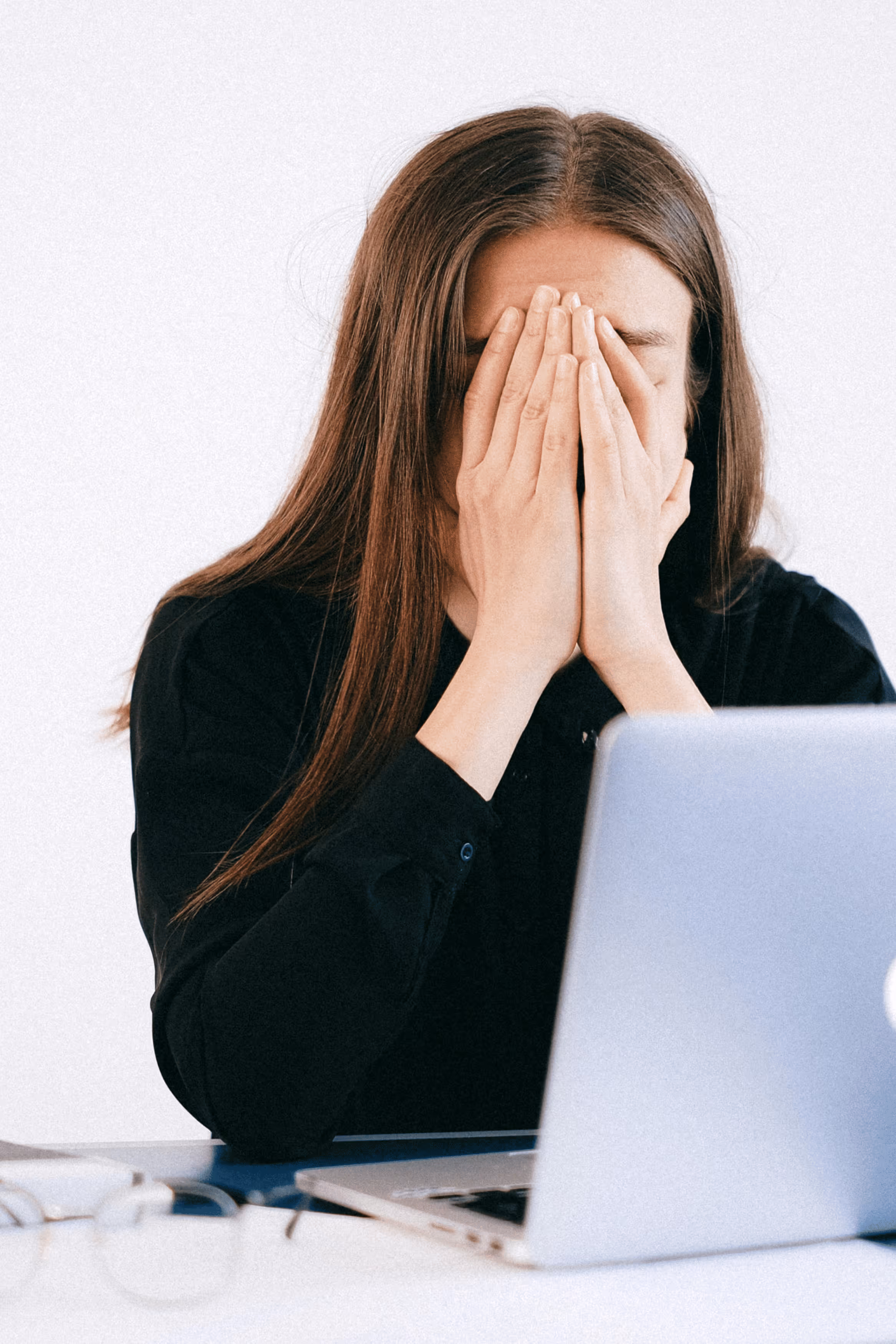 Woman sitting on couch holding her stomach in discomfort.