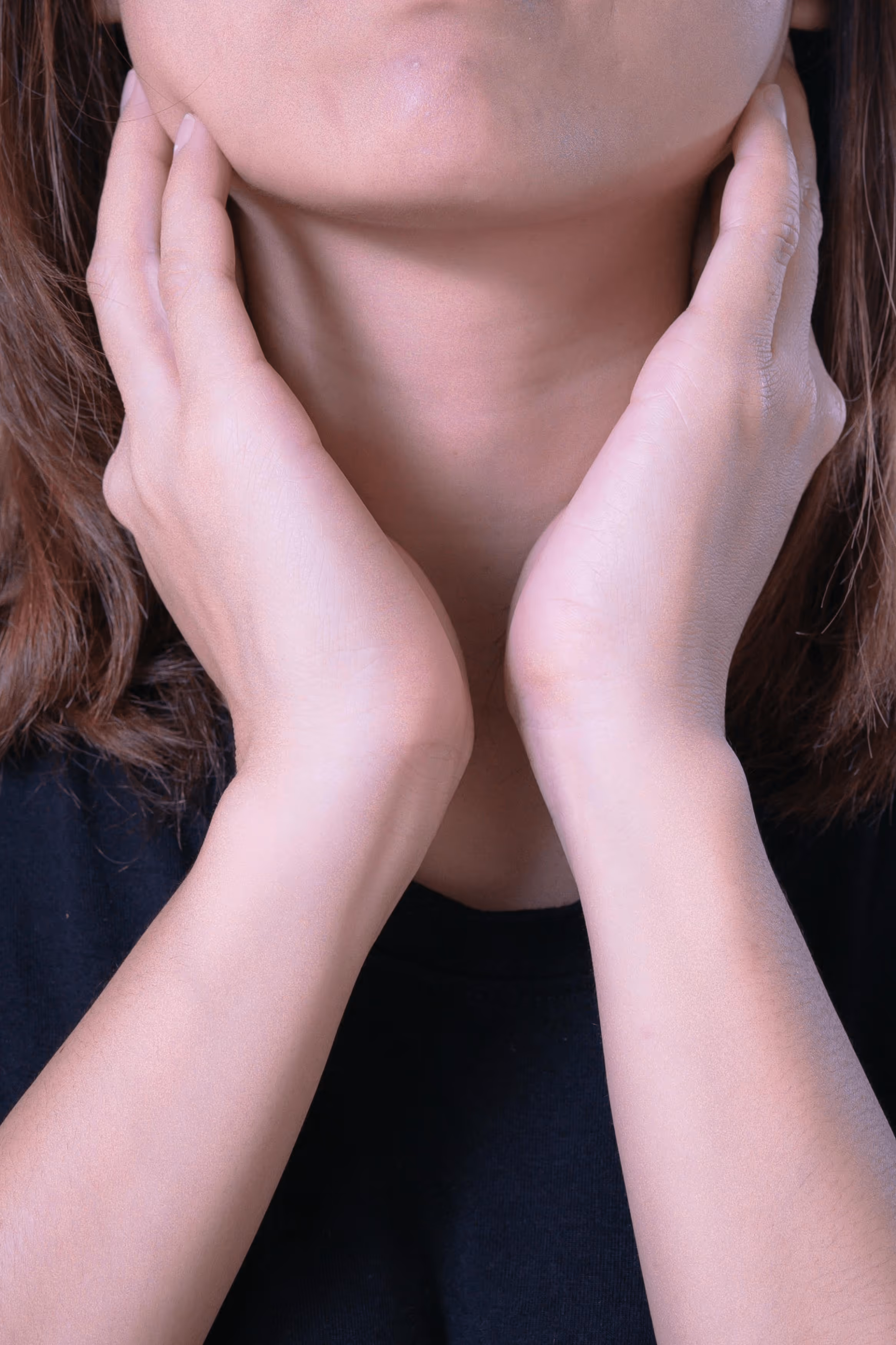 Woman sitting on couch holding her stomach in discomfort.