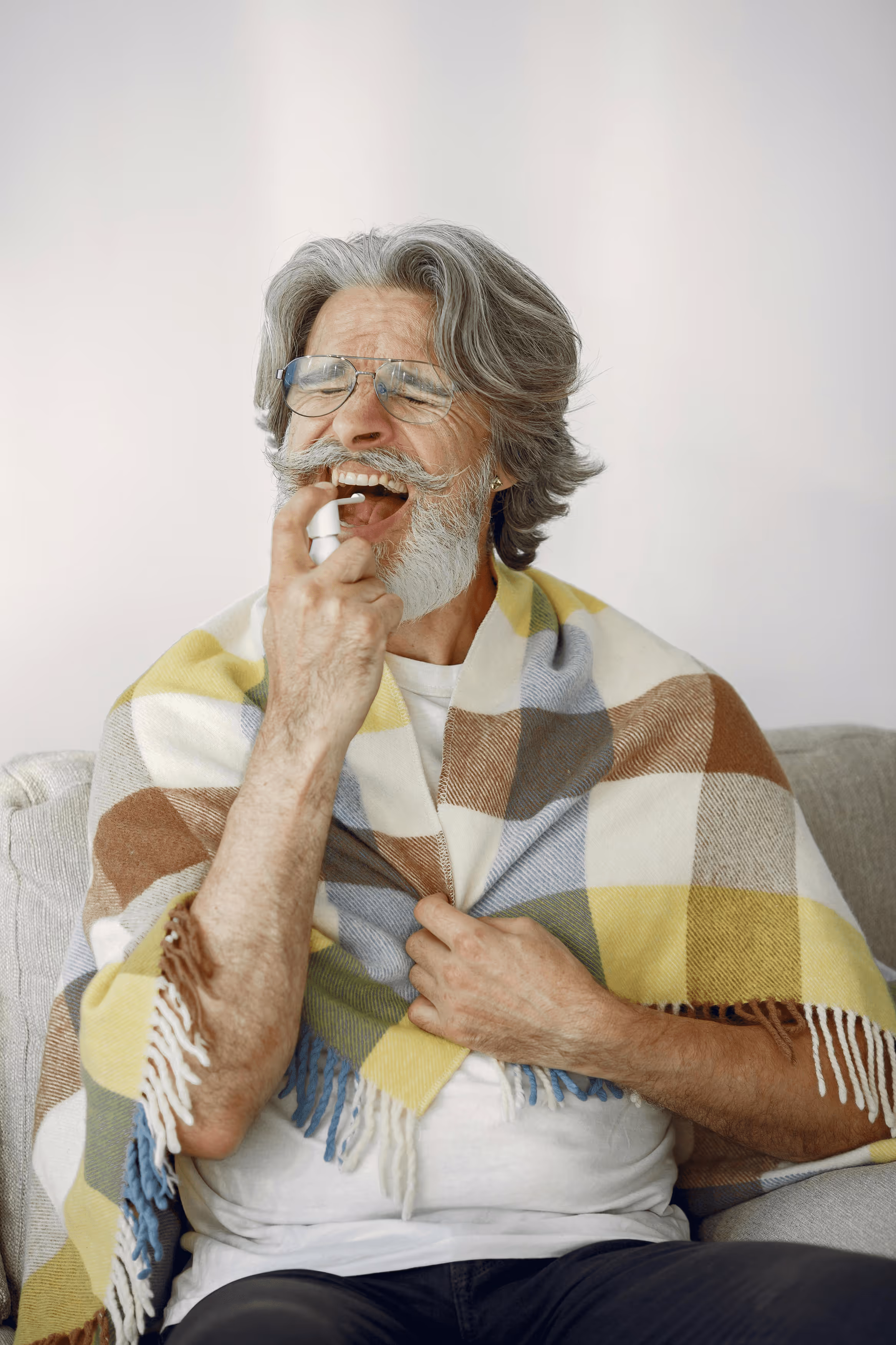 Woman sitting on couch holding her stomach in discomfort.