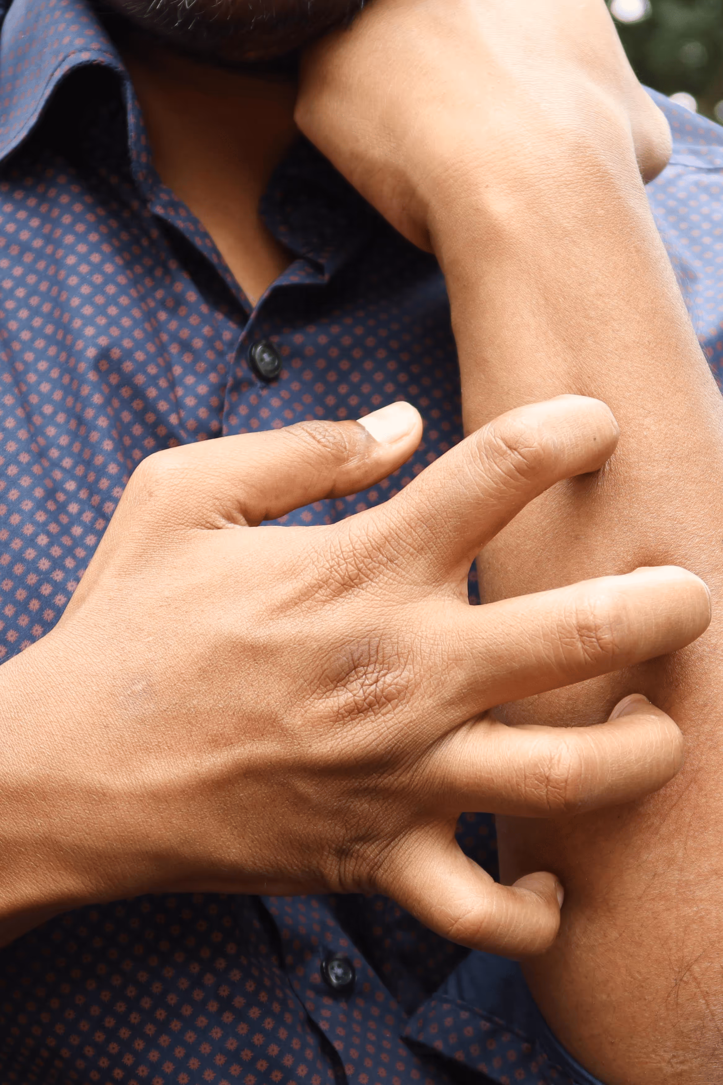Woman sitting on couch holding her stomach in discomfort.