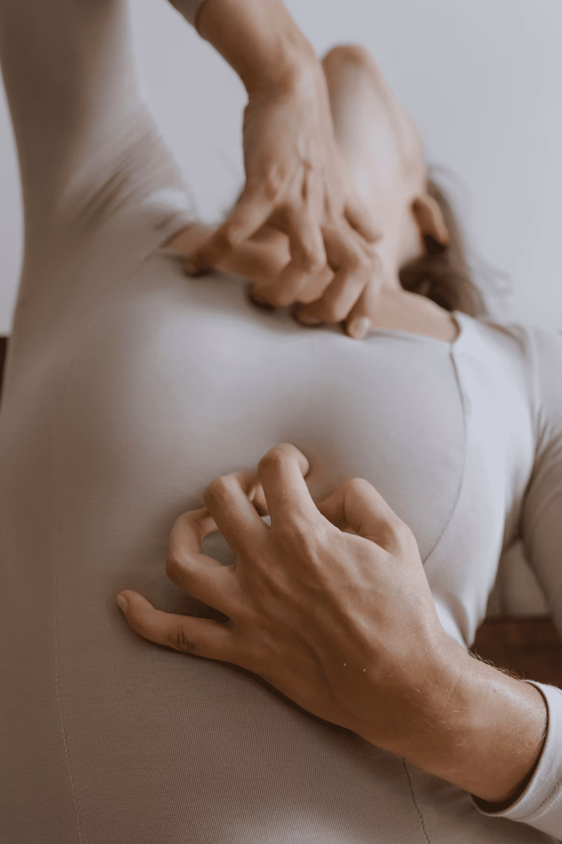 Woman sitting on couch holding her stomach in discomfort.