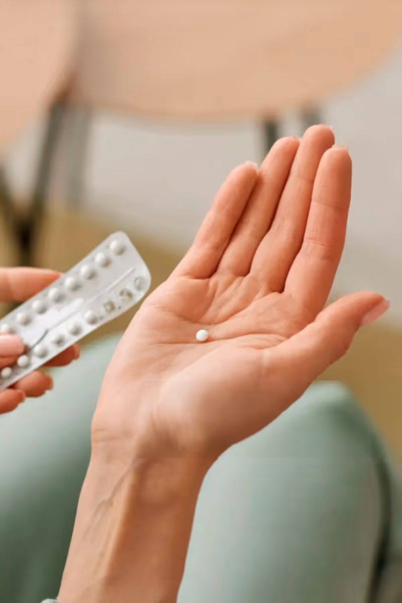 Woman holding blister pack with birth control pill in hand — Hedfirst contraception options.