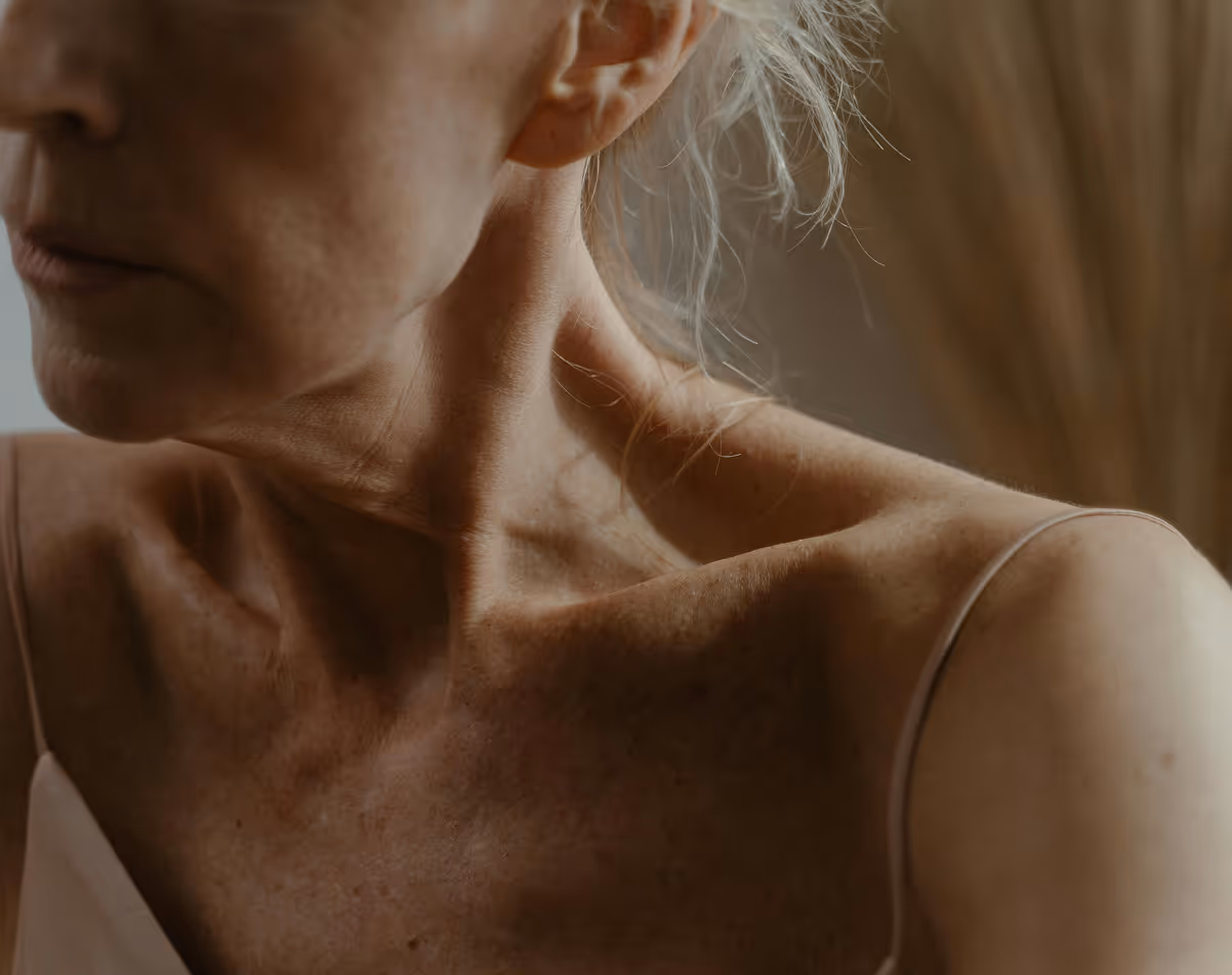 Close-up of mature woman’s décolletage, results of Hedfirst anti-aging skincare.